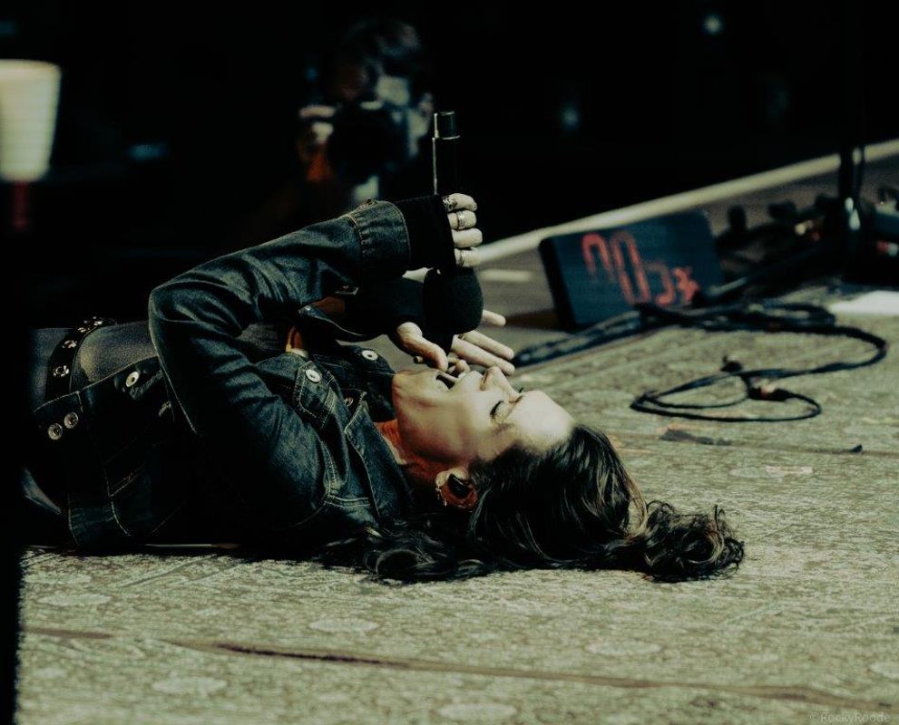 A person sings whilst lying on the stage.