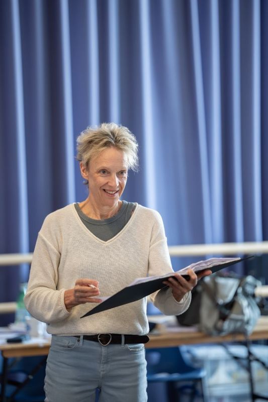 A woman is stood holding a book