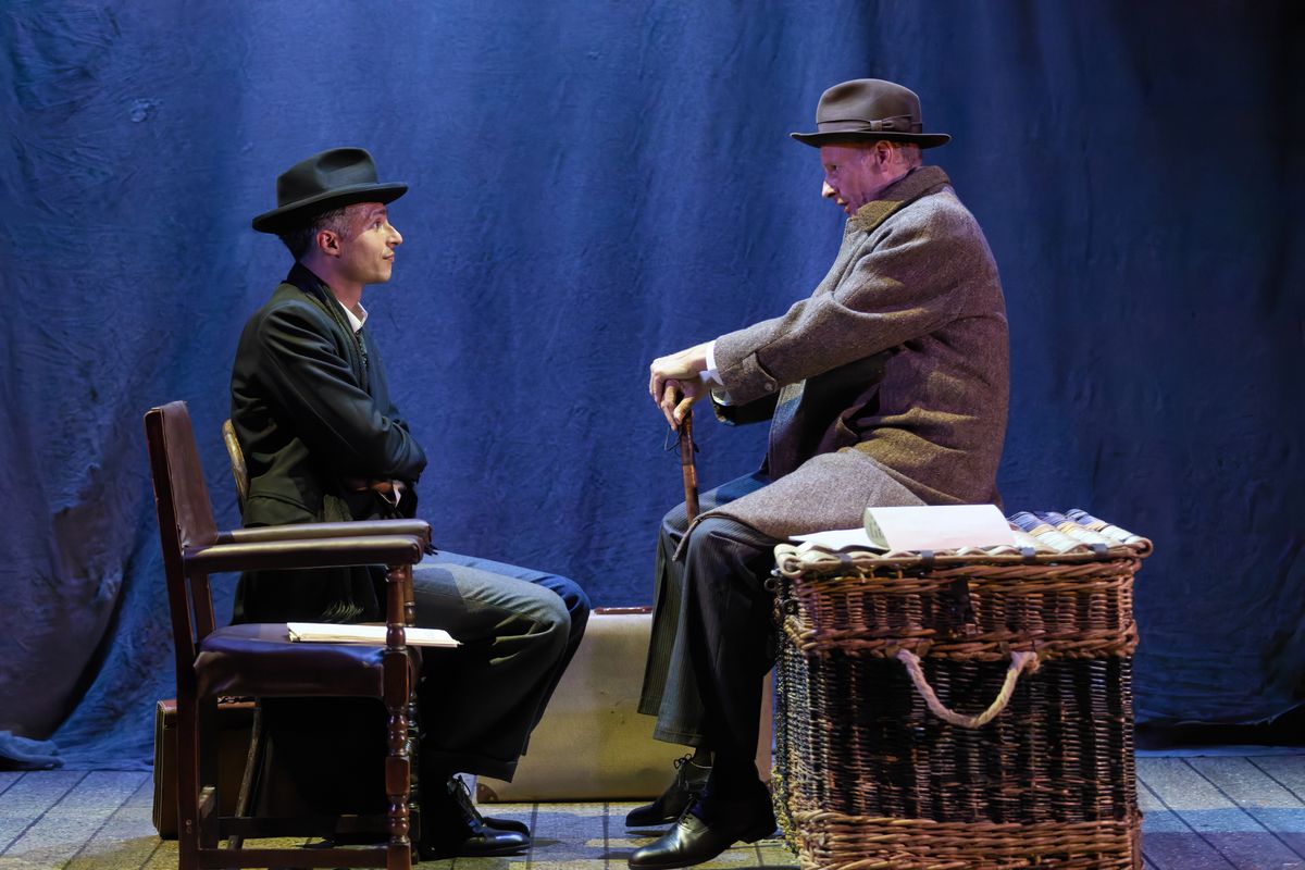 Two people in bowler hats sit looking at each other.