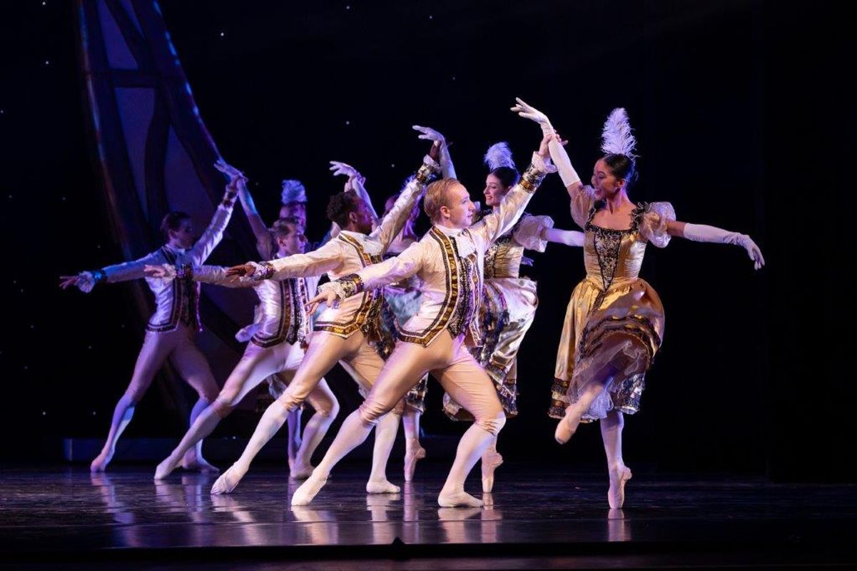 The Milwaukee Company dancing on stage for the production of Northern Ballet Cinderella. The are wearing Victorian styles costumes and are moving elegantly.