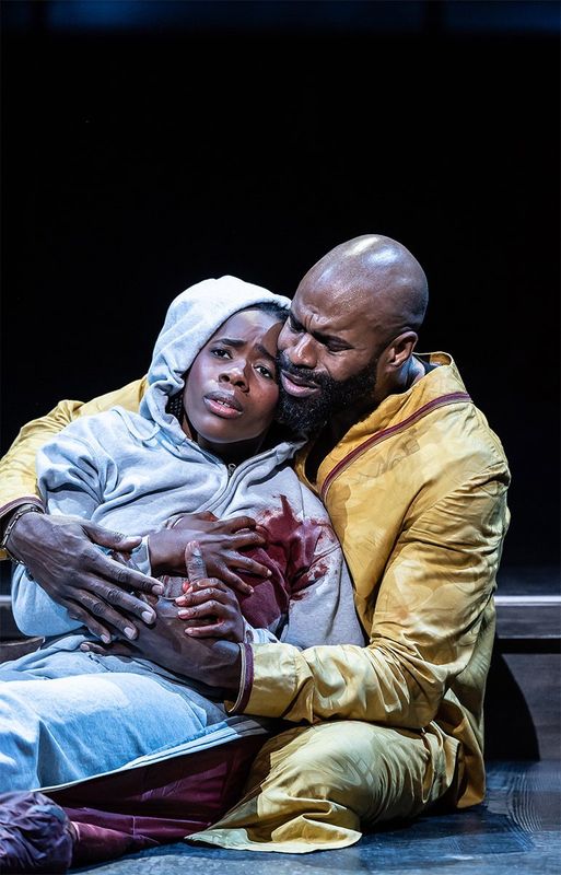 A person is holding another person who is bleeding from their chest