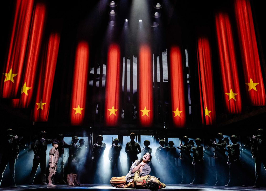 A person cries over a lifeless soldier.