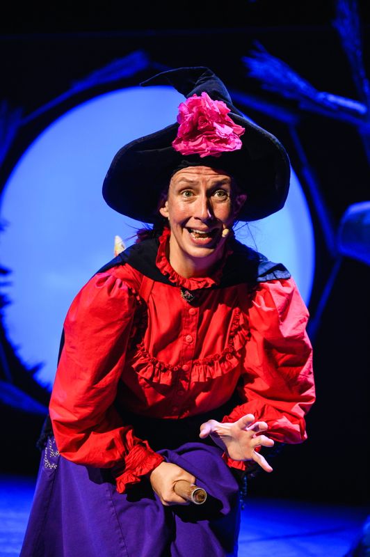 Actor playing a witch onstage.