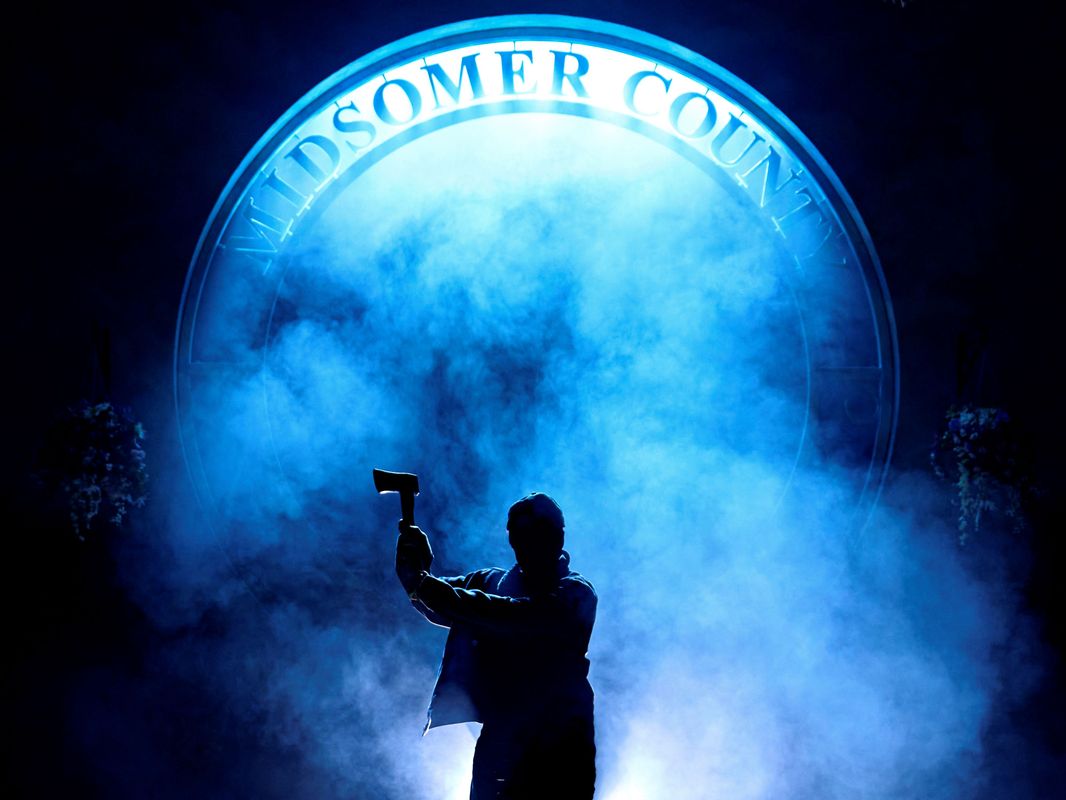 A dark figure holds an axe in the air.