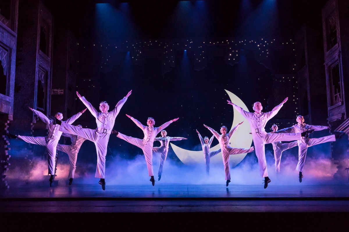 Dancers on stage in front of a moon