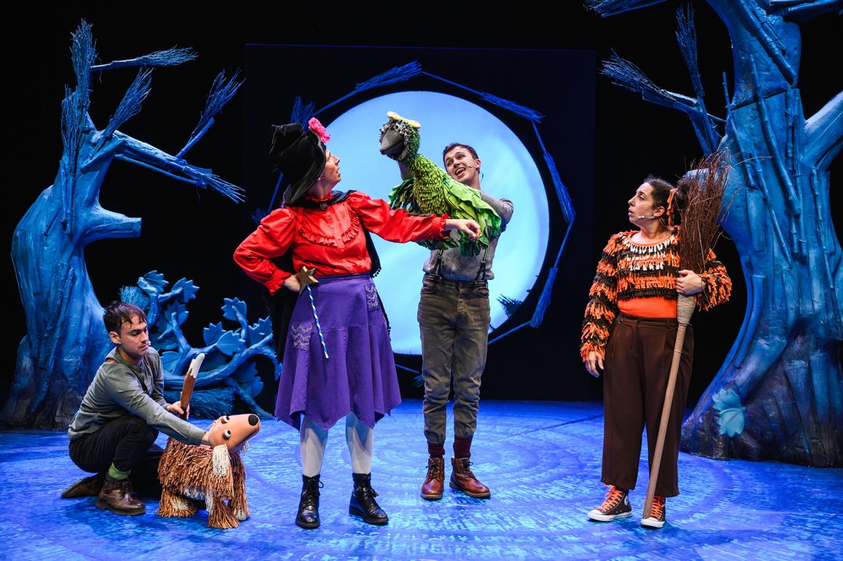 Group of actors onstage with animal puppets.
