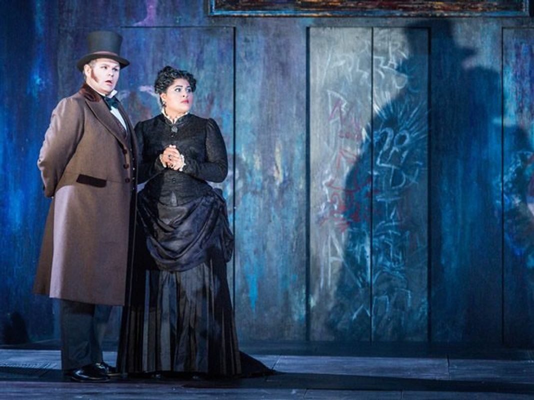 A man and woman are stood with each other, both wearing clothes from the Victorian era