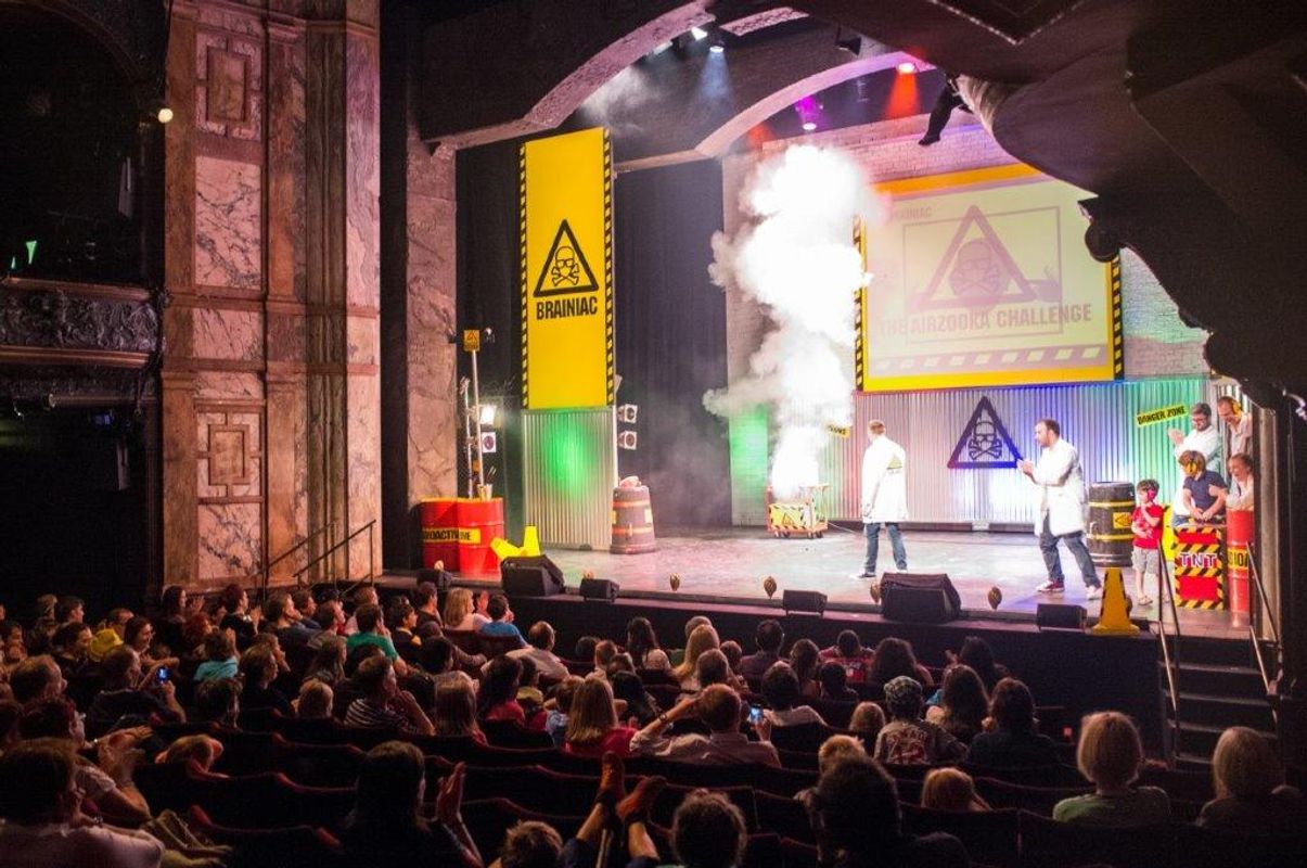 An audience watch an experiment on stage.