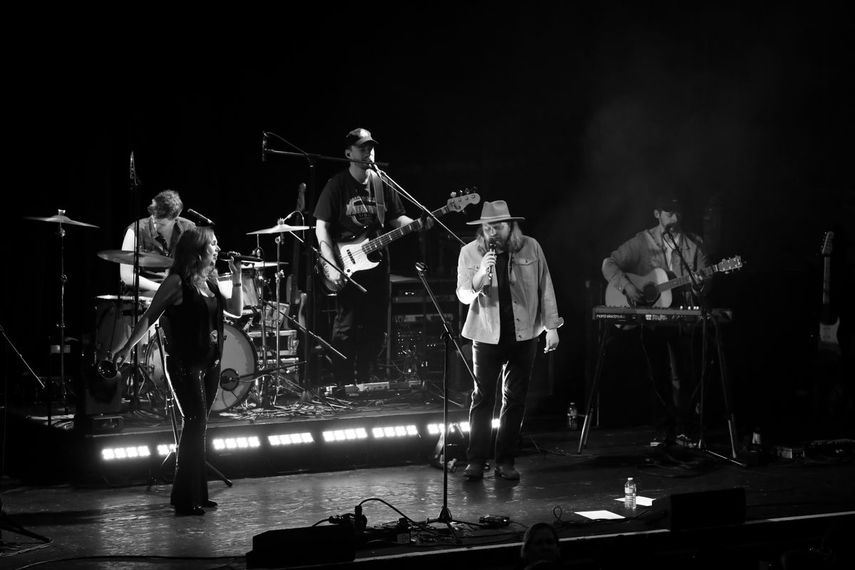 A black and white photograph shows two singers on stage.