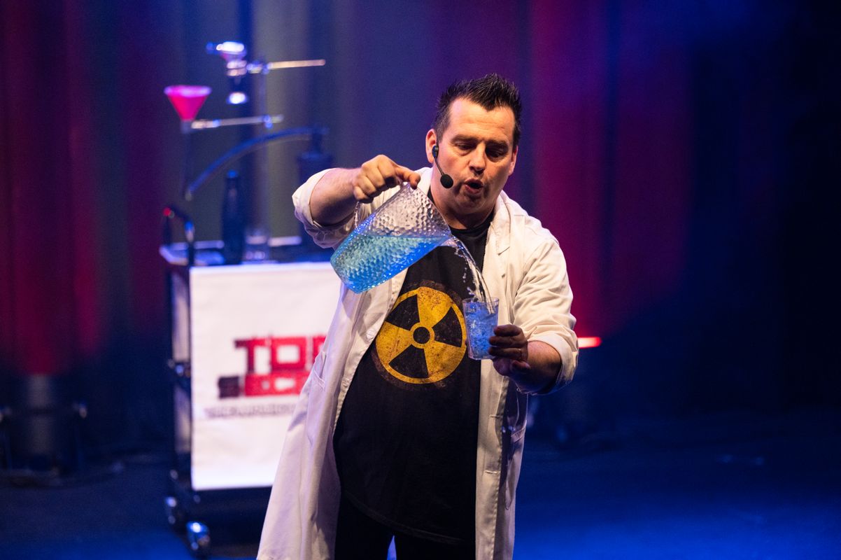 A person pours liquid into a glass.
