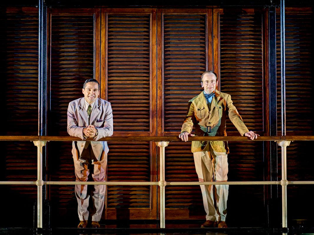 Two people stand on a high level looking out.