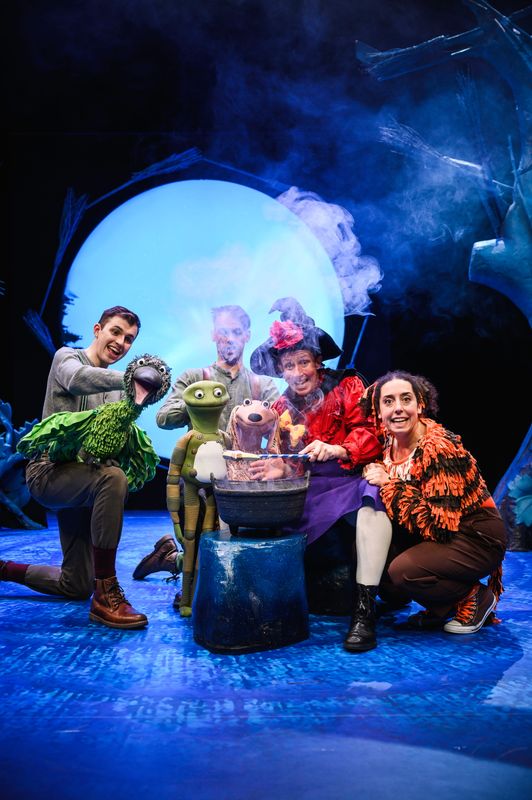 Group of actors onstage with animal puppets.