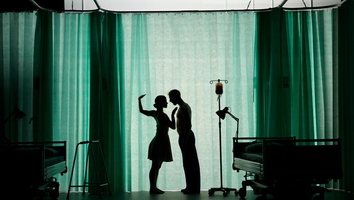 A silhouette of a man and woman behind a hospital curtain