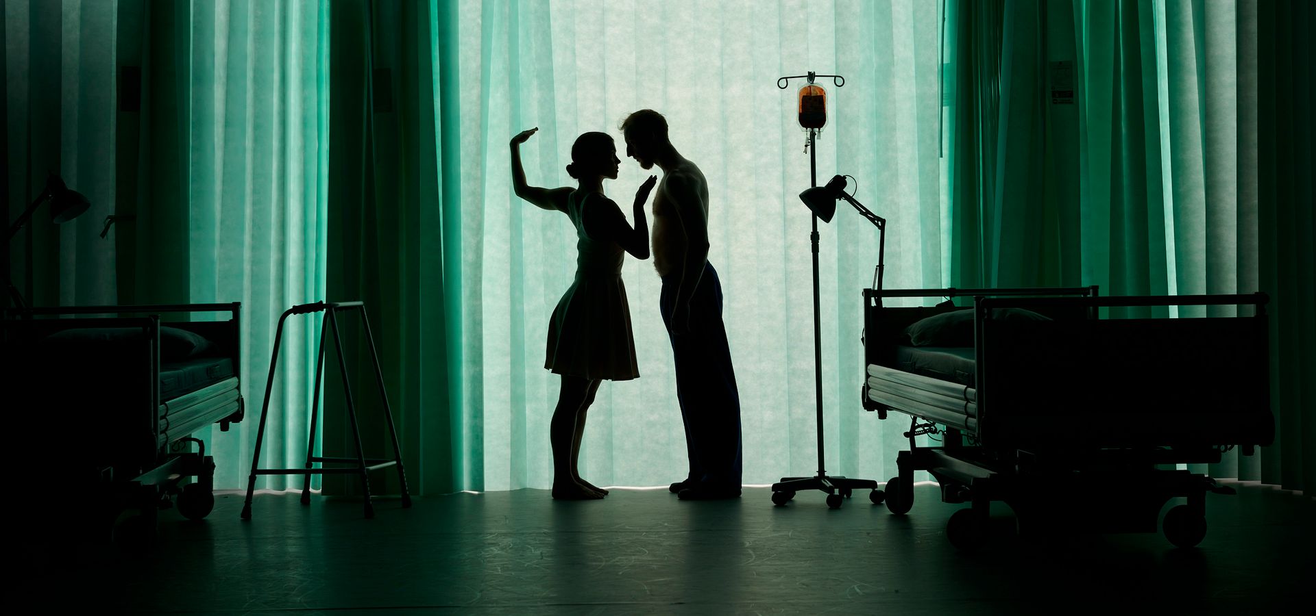 A silhouette of a man and woman behind a hospital curtain