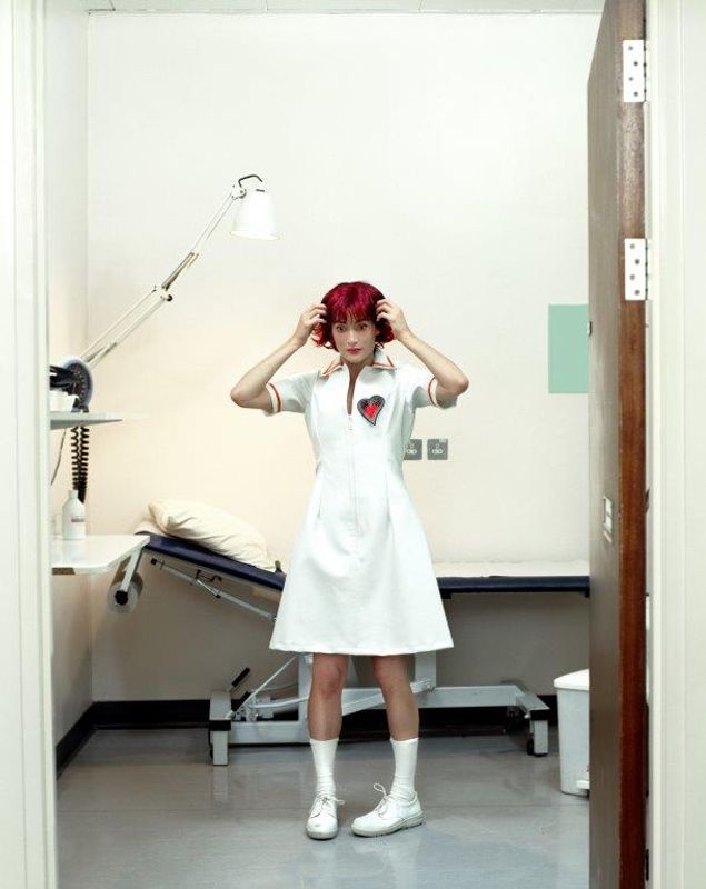 Person dressed in a white nurses outfit in a hospital room