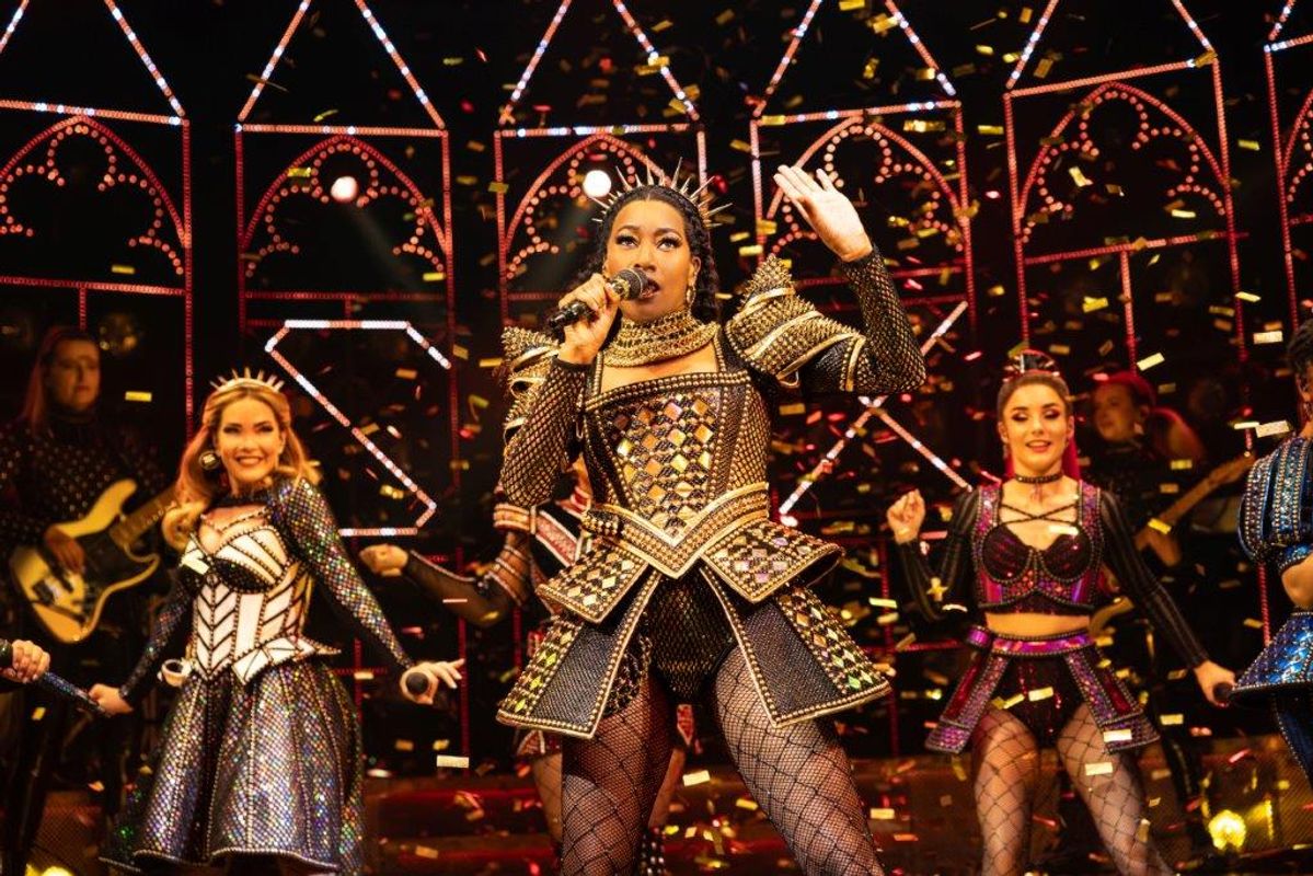 Gold confetti surrounds three people on stage.