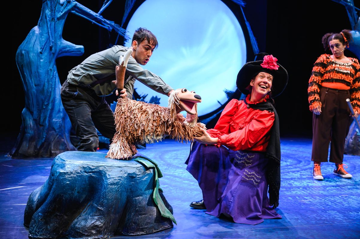Group of actors onstage with animal puppets.
