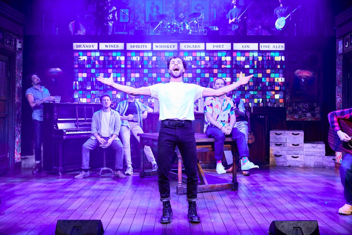 A person stands centre stage singing out to the audience.