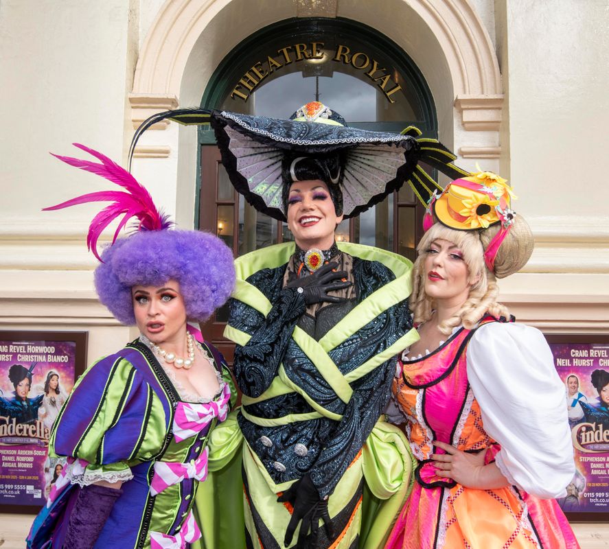 The wicked stepmother and stepsisters pose to the camera outside the Theatre Royal entrance.