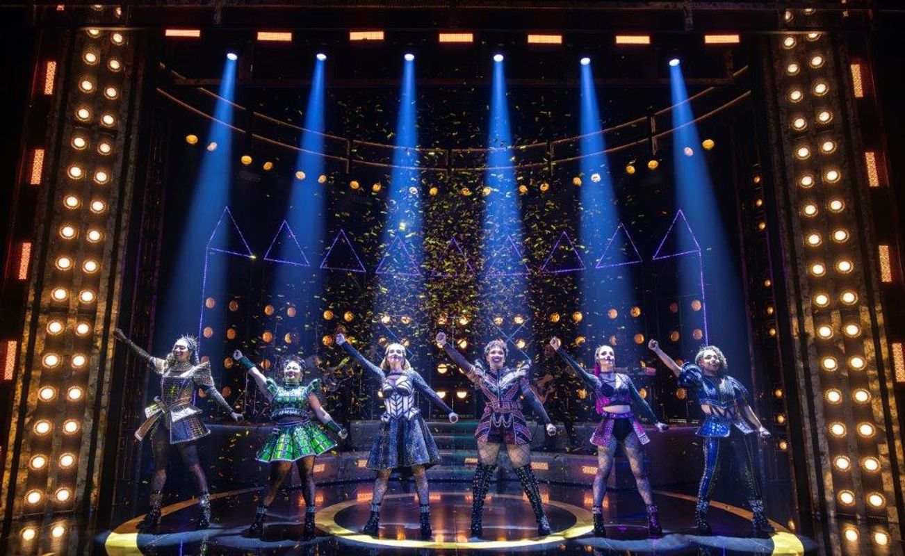 Six people stand triumphantly with their right arm outstretched.