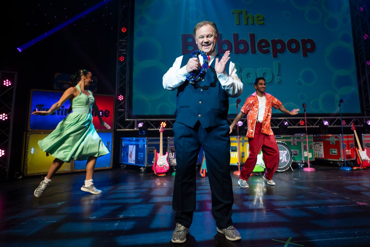 Justin smiles to the camera playing his tambourine.