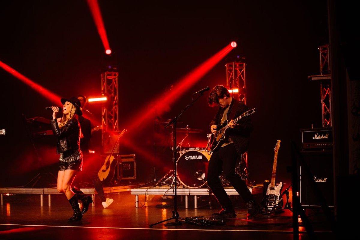 Country singers performing on stage wearing cowboy hats and playing instruments