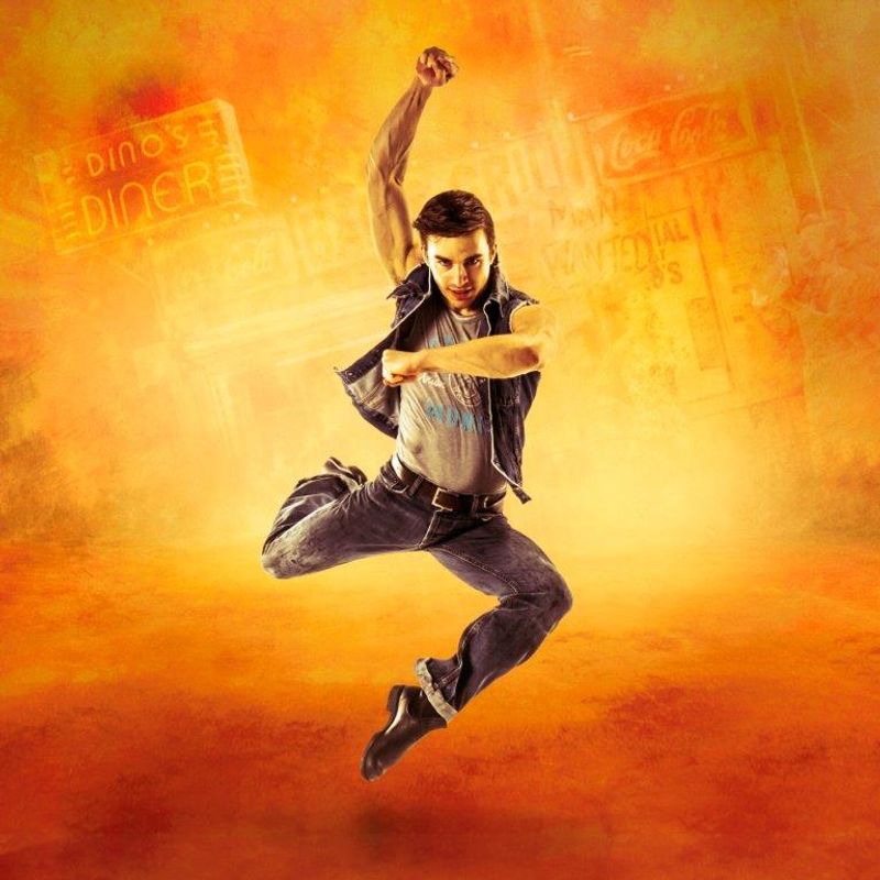 A dancer in denim leaps energetically against a vibrant orange backdrop. Behind him, the neon sign for "Dino's Diner" is visible, adding a retro vibe.