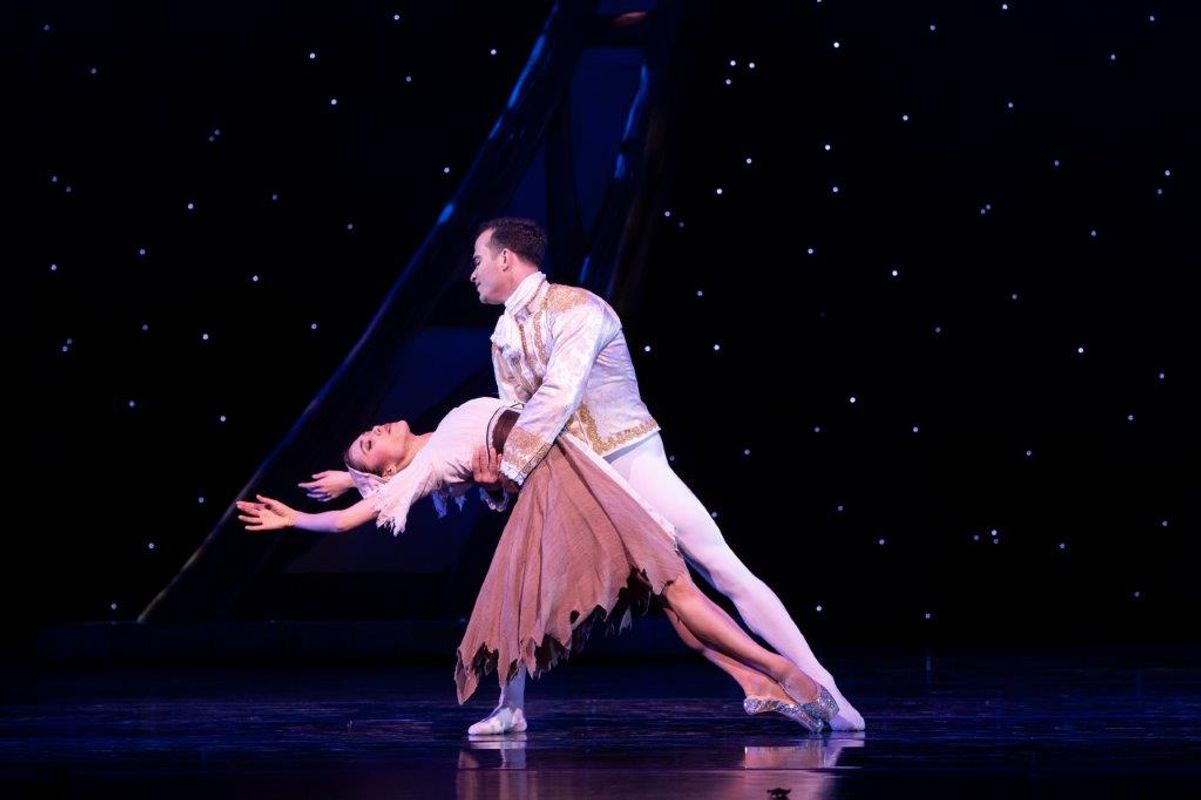 The Milwaukee Company dancing on stage for the production of Northern Ballet Cinderella. The are wearing Victorian styles costumes and are moving elegantly.