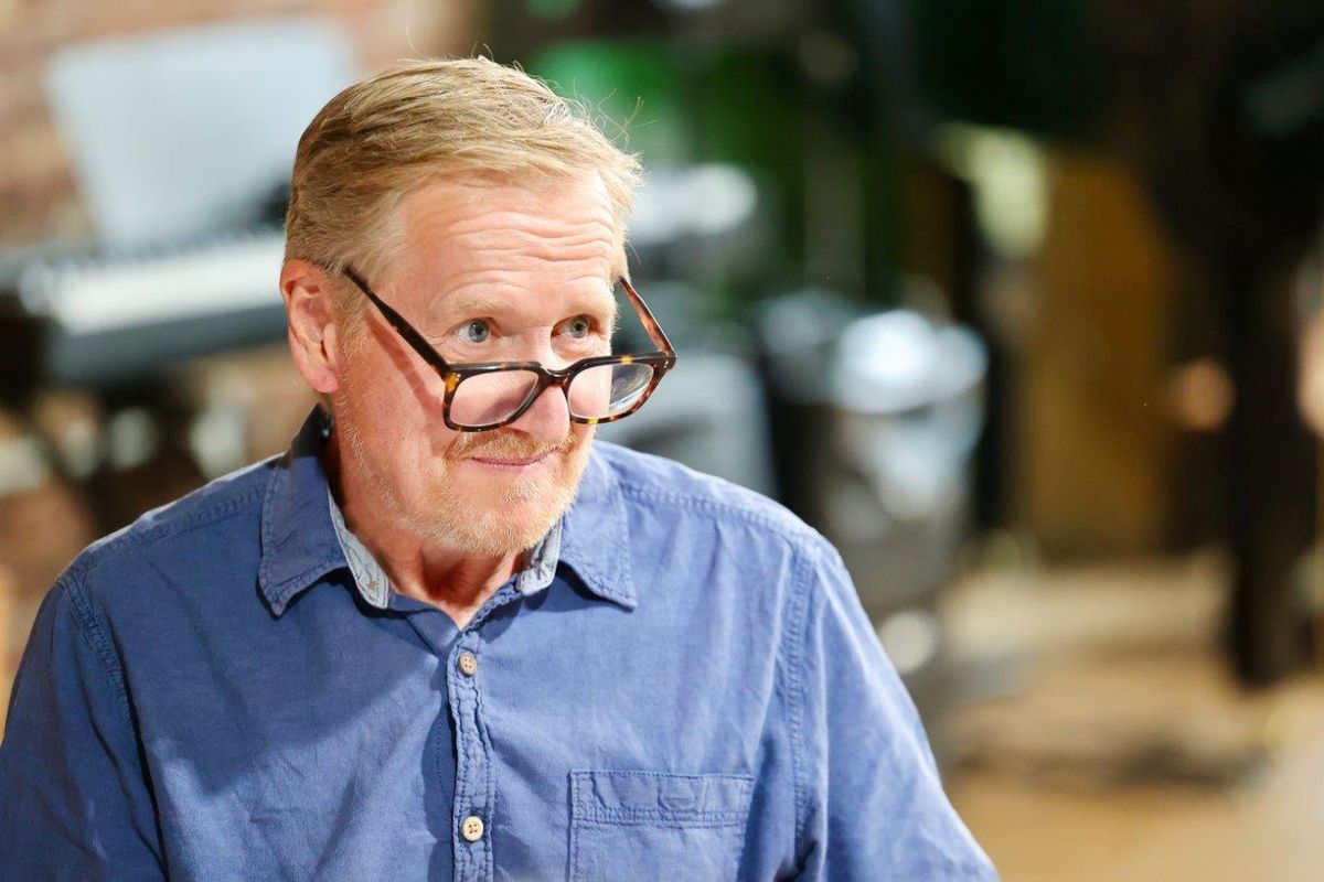 A man looking over his glasses, he is wearing a blue shirt
