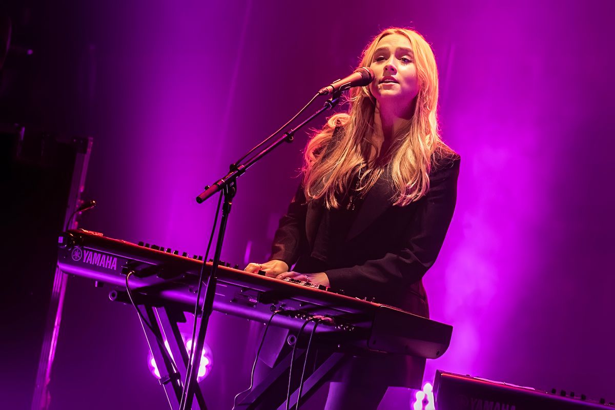 A person plays keyboard lit by purple light.