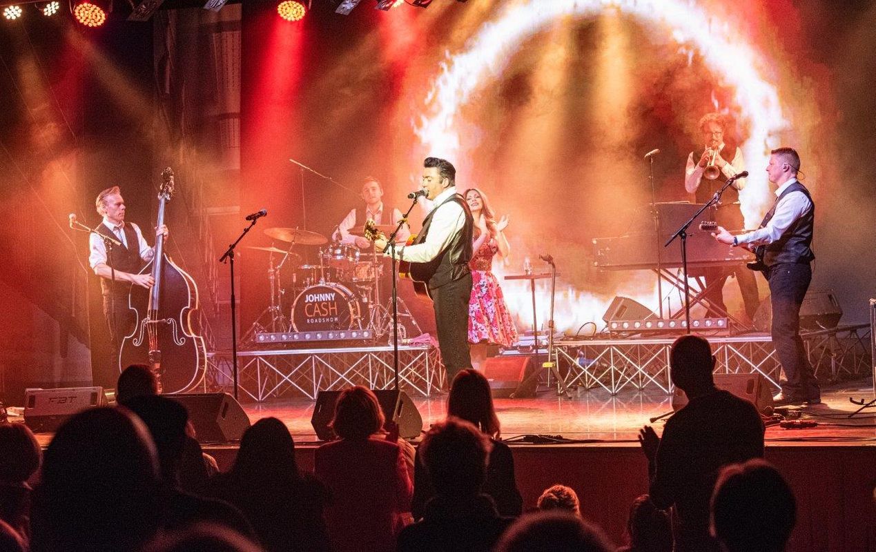 Johnny Cash Roadshow and band performing on stage.