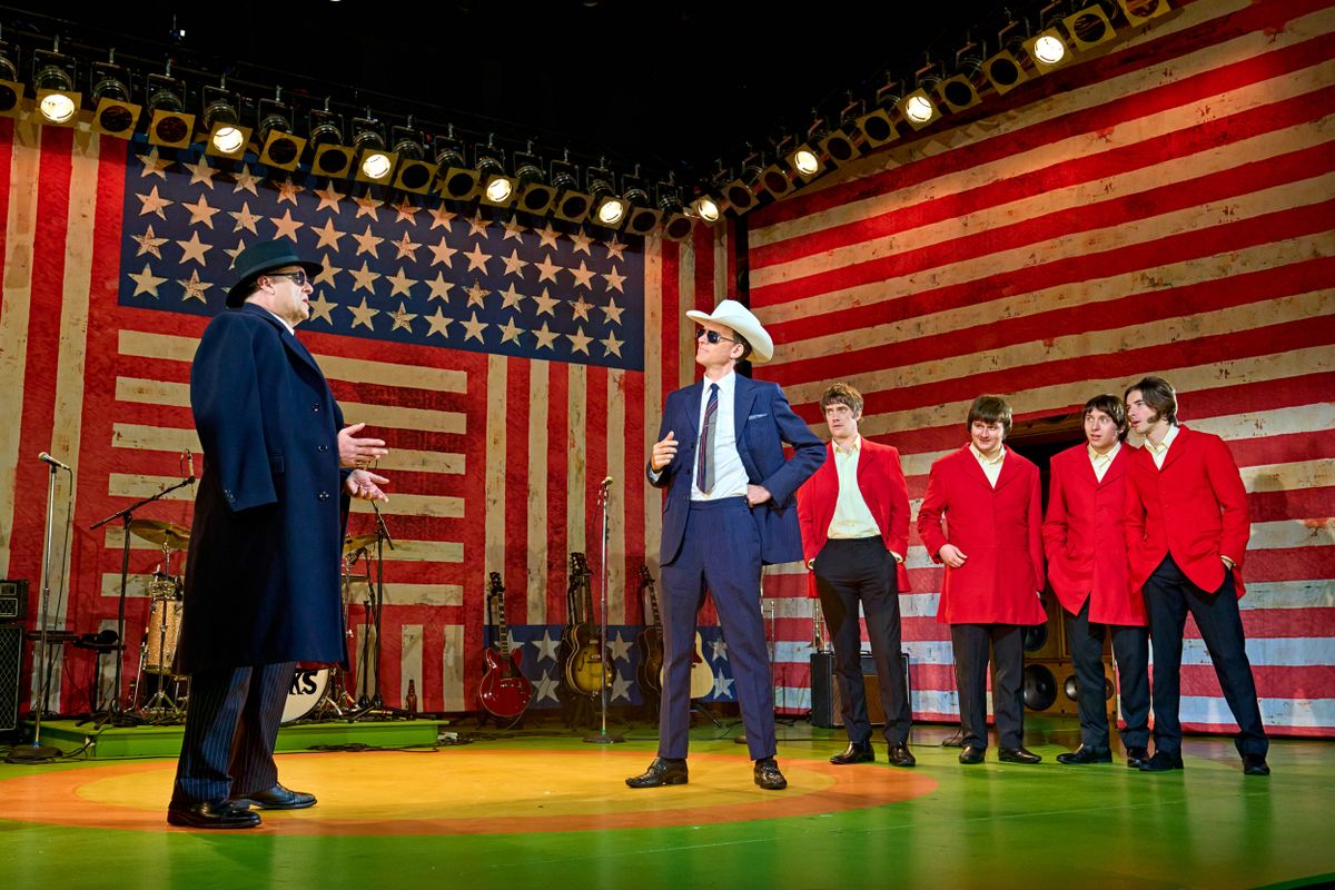 The American flag dressed the backdrop with two people dressed in black suits  talking centre stage,.