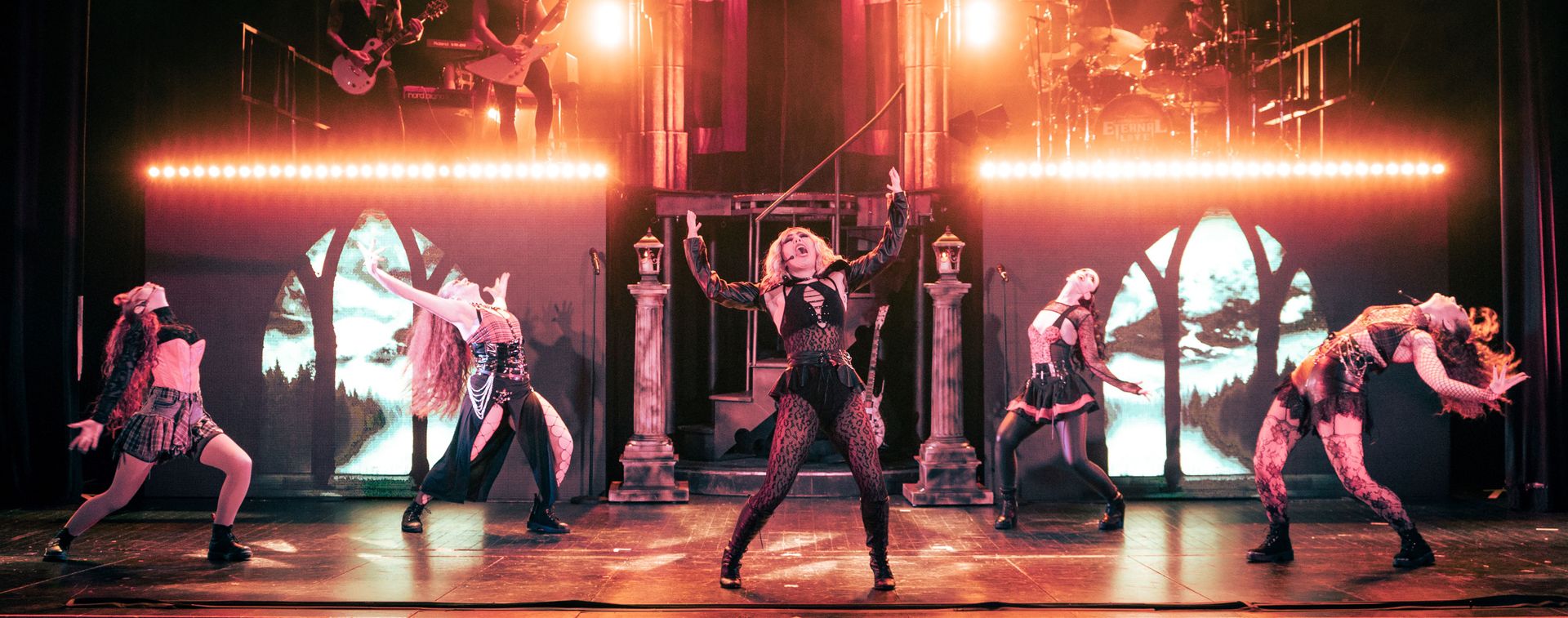 Five people bend backwards with their arms flaring