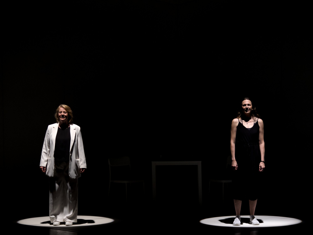 Two people stood side by side and a spotlight is shining on them
