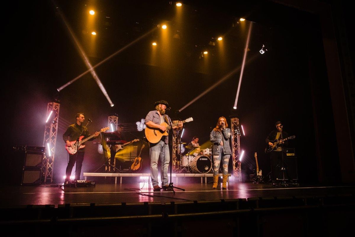 Country singers performing on stage wearing cowboy hats and playing instruments