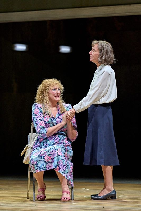 There are two people, one is comforting the other as they cry