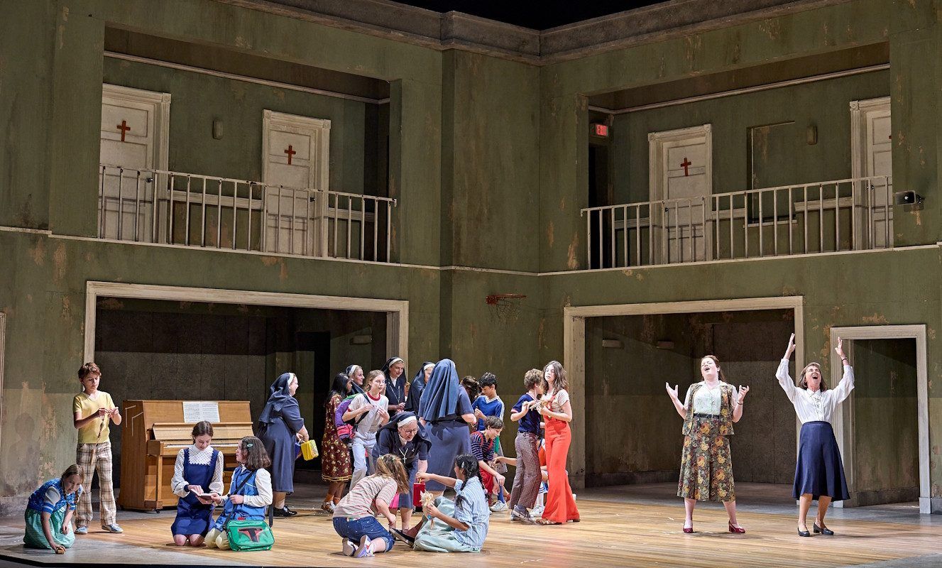 There are two people in a room with nuns and children, it looks to be a happy scene