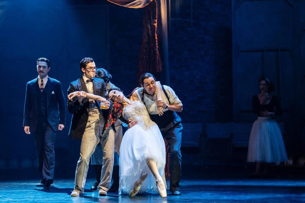 Two people carry a third person dressed in a white dress.