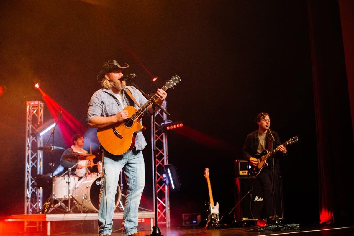 Country singers performing on stage wearing cowboy hats and playing instruments