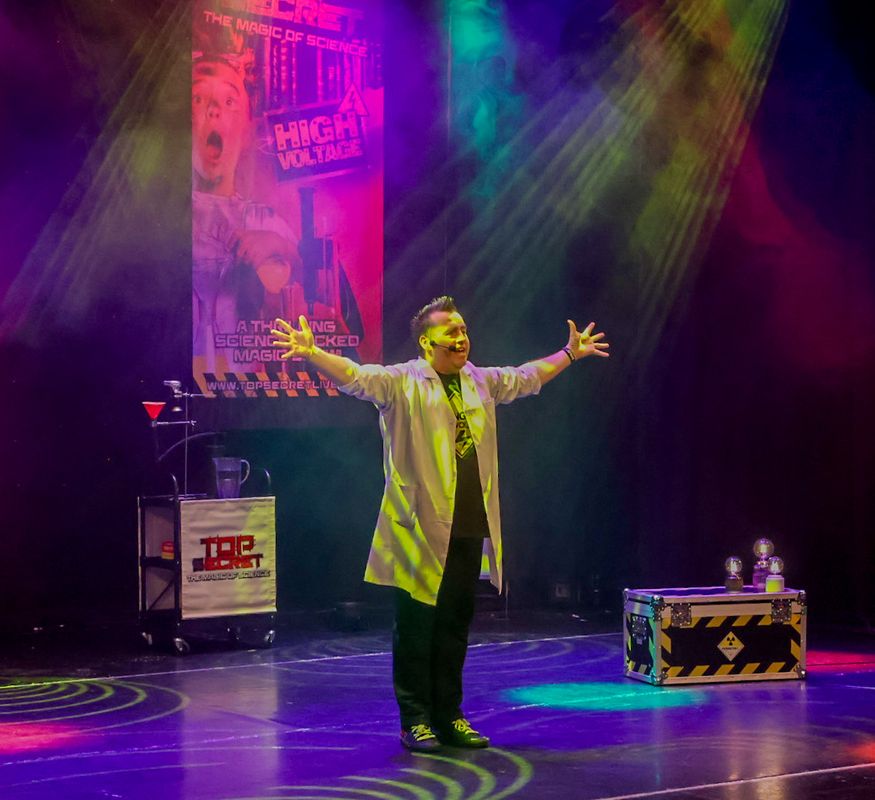 A person in a white lab coat stands with their arms outstretched.