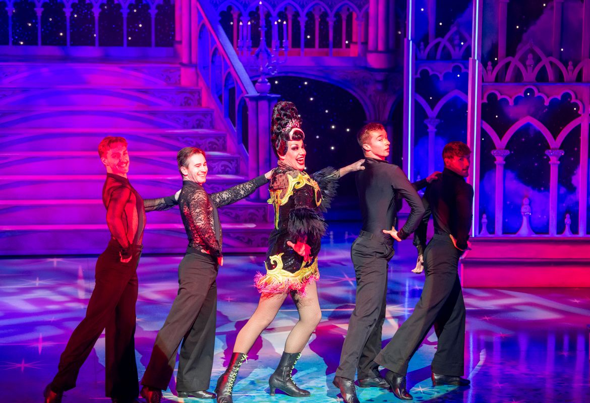 The Wicked stepmother stand in a line surrounded by 4 ensemble members looking over their right shoulders.