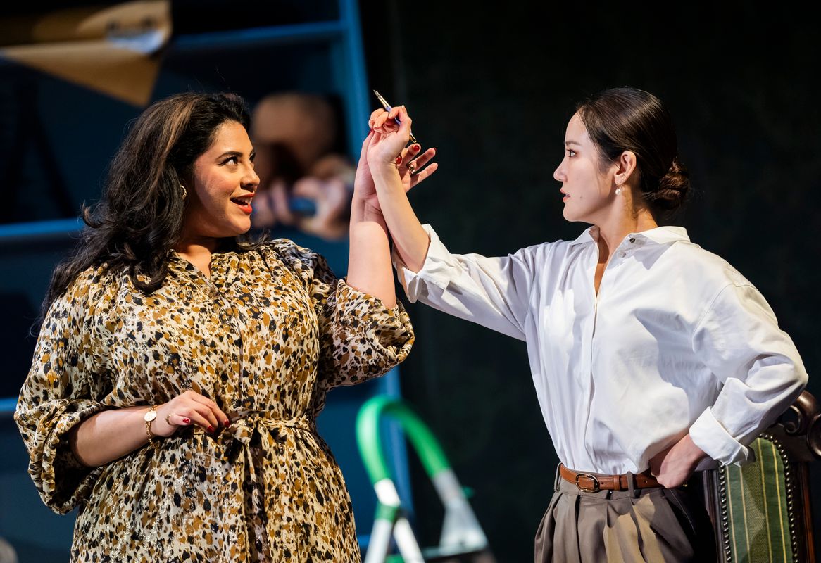 Two people looking at each other one is holding the other one's arm in the air