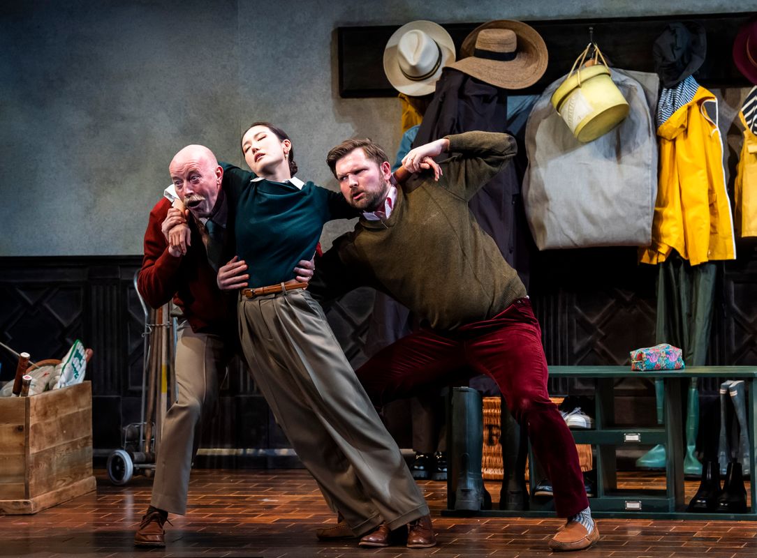 Three people, two of the are holding the third person up as they appear to be sleeping.