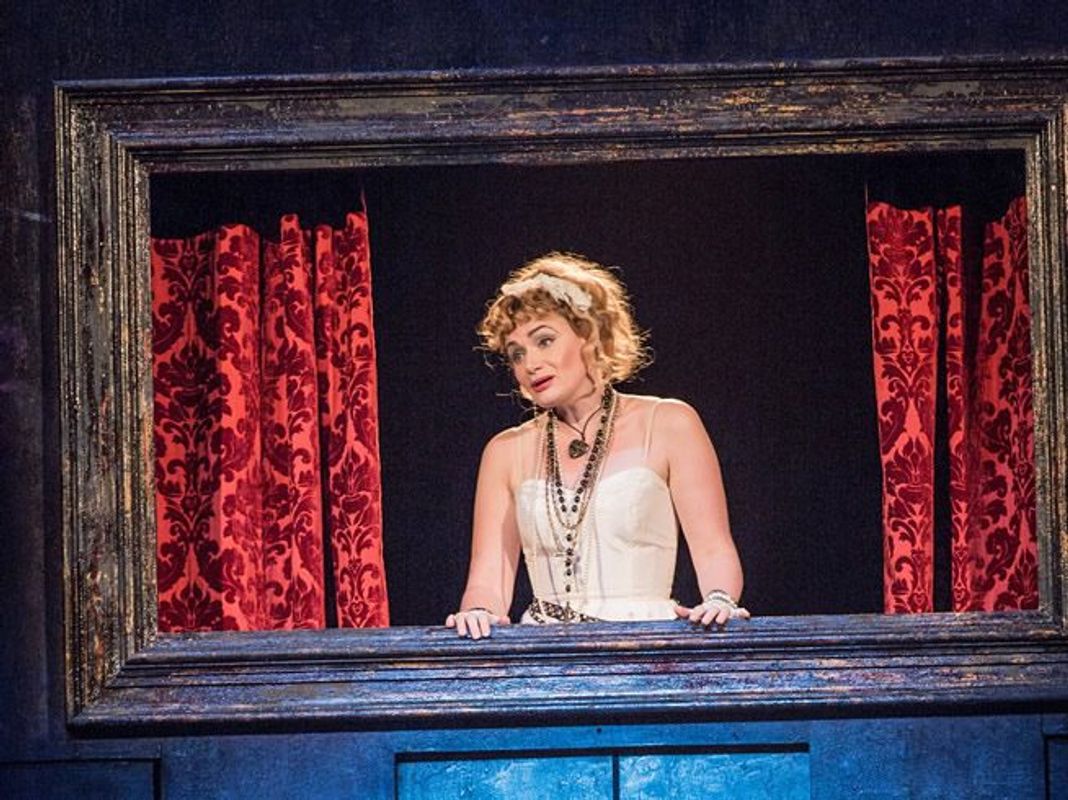 There is a person wearing rosary beads. They are looking out of a window