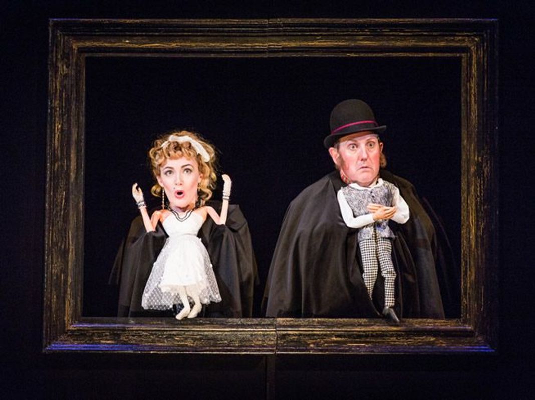 There are two people wearing black cloaks and they are wearing little bodies so them appear smaller