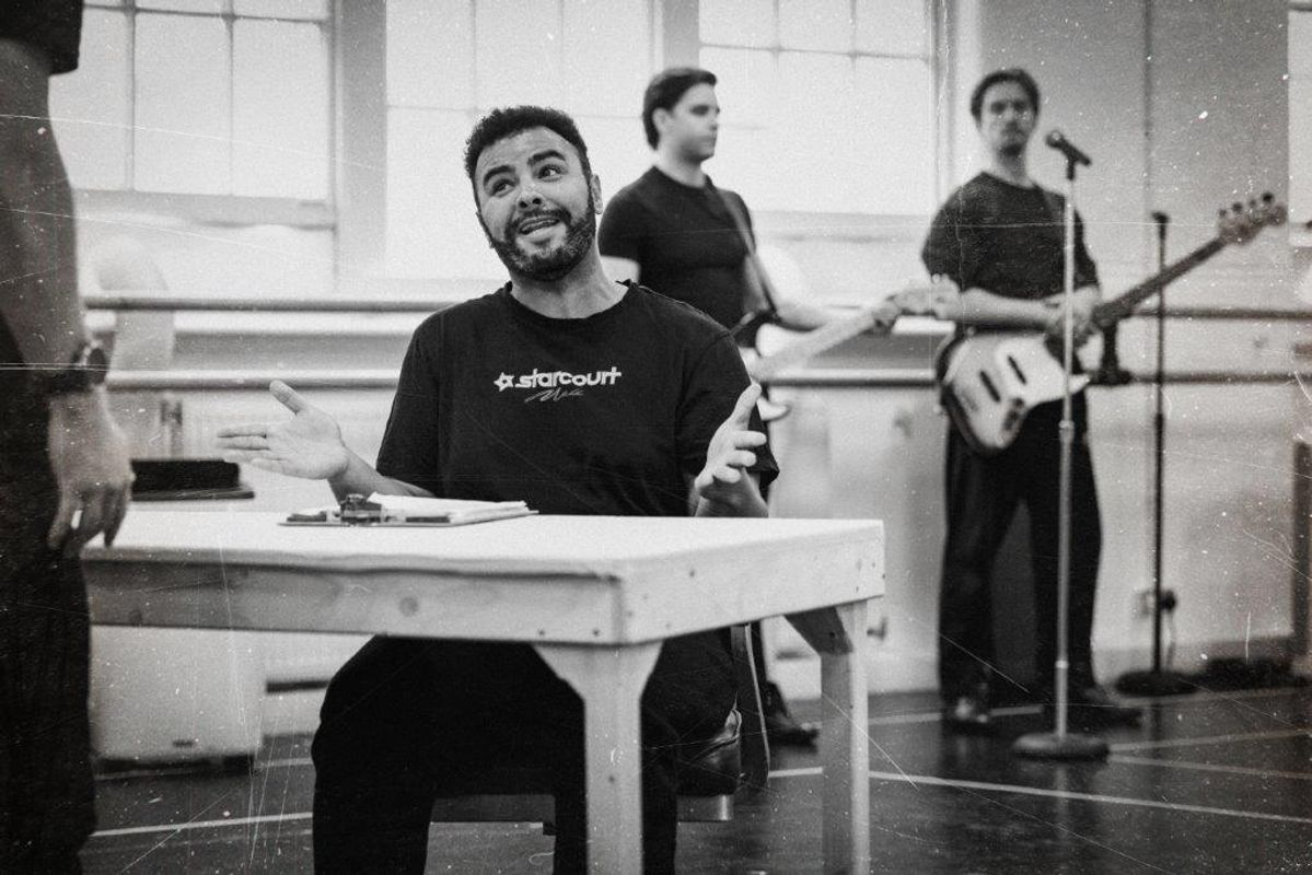 Black and white image of cats members rehearsing for Jersey boys. They are all wearing black and in a rehearsal studio