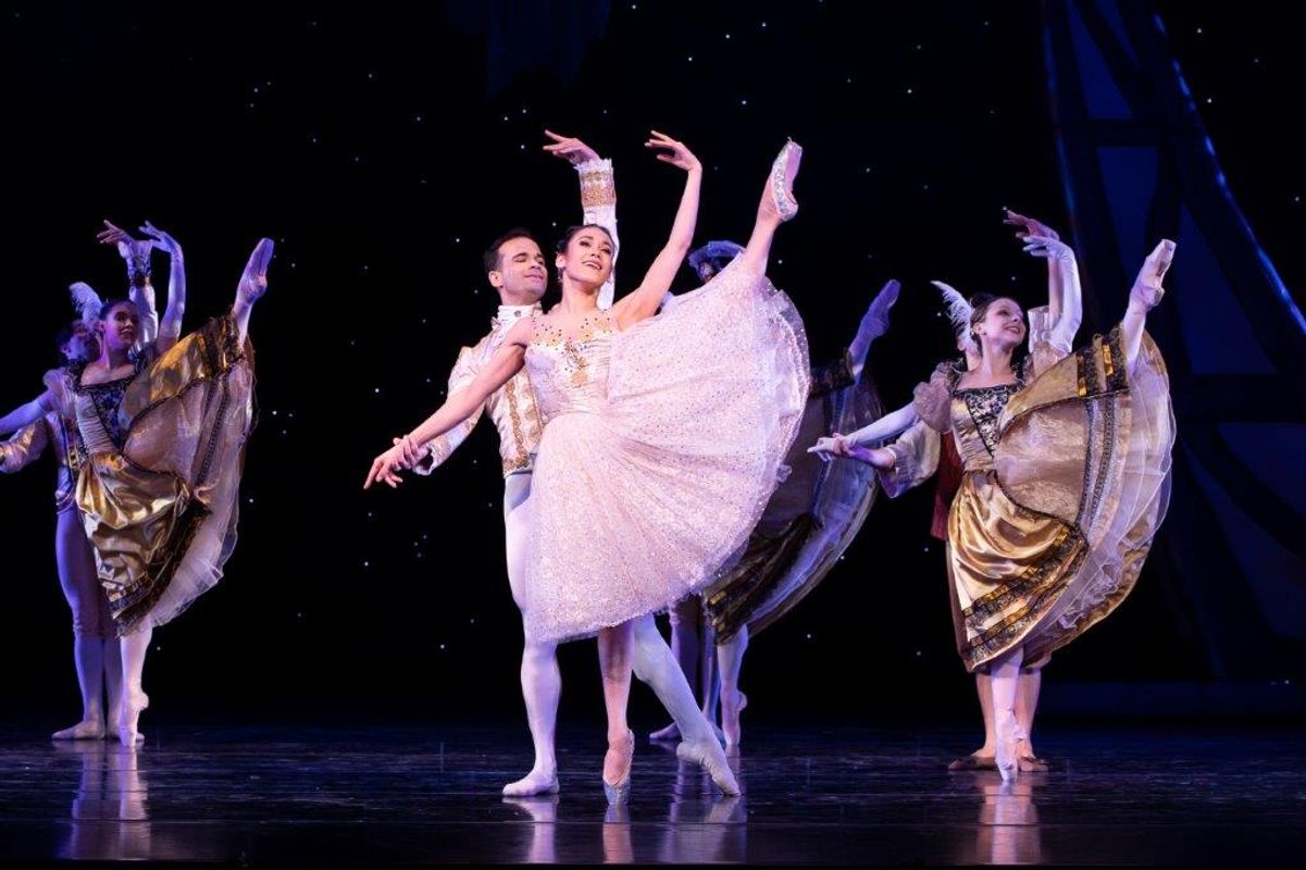 The Milwaukee Company dancing on stage for the production of Northern Ballet Cinderella. The are wearing Victorian styles costumes and are moving elegantly.