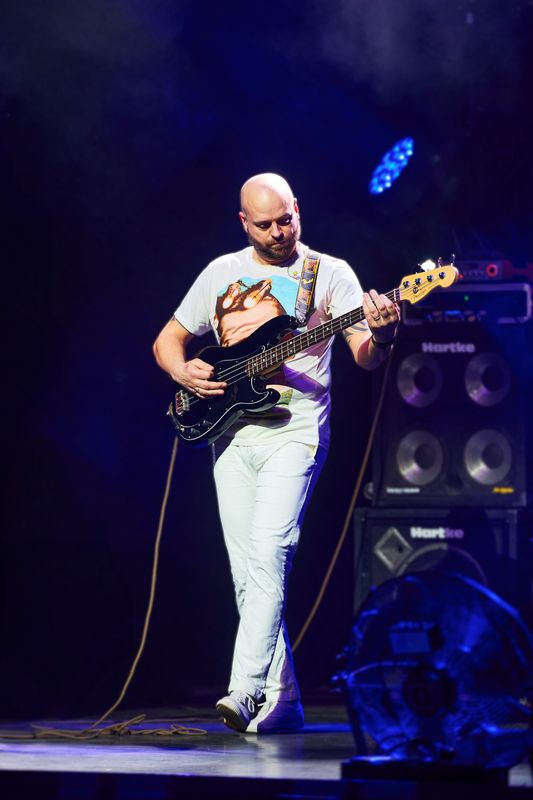 A man on stage playing a bass guitar