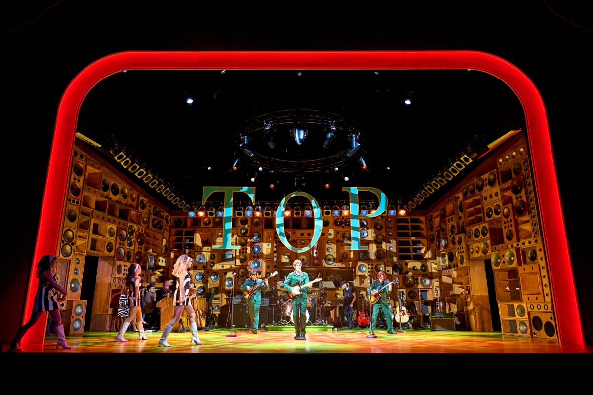 The band play centre stage with three dancers dressed in 1960 mini dresses walking on.