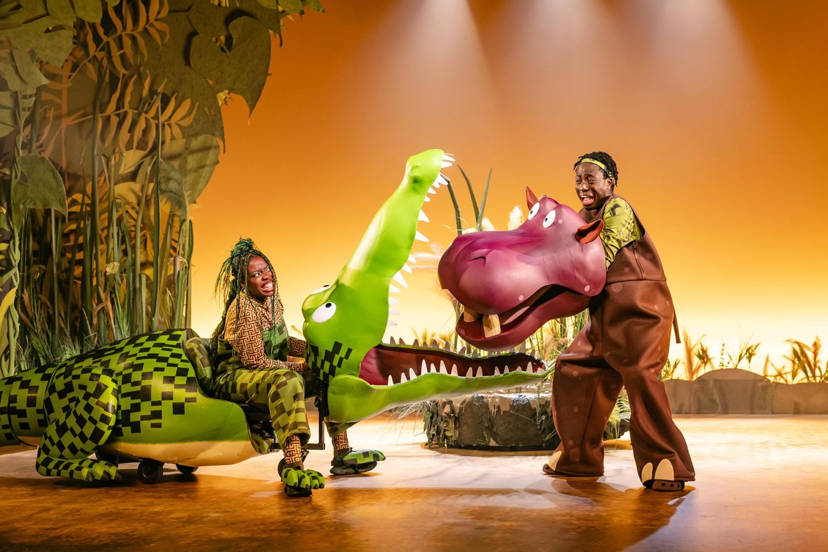 The crocodile has it's mouth open and the hippos head is nearly in it